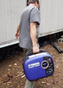 man carrying an inverter generator